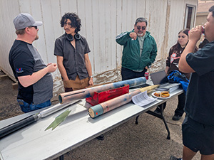 four students talking about the rockets on the table