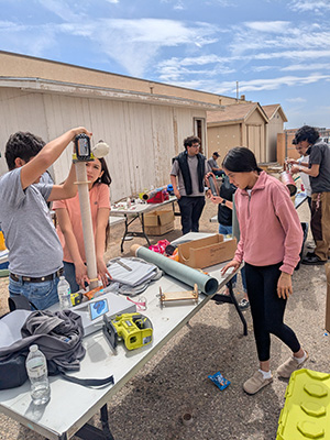 Students working on a rocket standing up